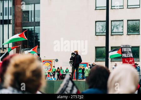 Le conférencier masculin s'adresse à la foule lors de la marche pro-Palestine avec des drapeaux palestiniens et des panneaux Palestine libre. Newcastle upon Tyne, Angleterre, Royaume-Uni - octobre 28 2023. Banque D'Images