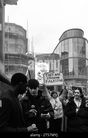 Un manifestant tient un panneau fait à la main indiquant "ils affament la Palestine". Grey's Monument, Newcastle upon Tyne, Angleterre, Royaume-Uni - octobre 28 2023. Banque D'Images