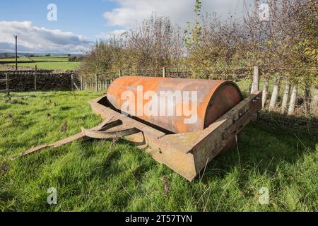 Rouleau de champ garé, rouleau de paddock, rouleau de terre, utilisé pour aplatir la terre. Vu à Little Newton, long Preston, North Yorkshire. Banque D'Images