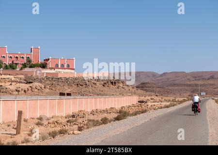 Cycliste sur la route du désert dans le sud du Maroc Banque D'Images