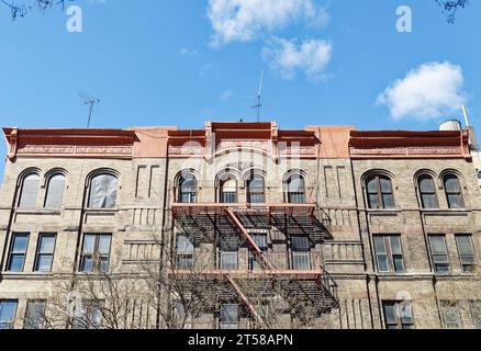 Un immeuble de construction délabrée en briques brunes construit vers 1910 ; les deux derniers étages semblent vacants. Banque D'Images