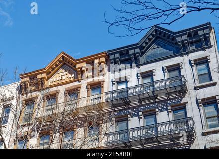 Les 249 et 251 East 77th Street sont des immeubles d'appartements en grès brun jumelé miroir de cinq étages avec des magasins au rez-de-chaussée dans l'Upper East Side. Banque D'Images