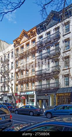 Les 249 et 251 East 77th Street sont des immeubles d'appartements en grès brun jumelé miroir de cinq étages avec des magasins au rez-de-chaussée dans l'Upper East Side. Banque D'Images