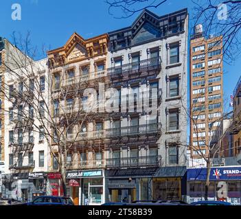 Les 249 et 251 East 77th Street sont des immeubles d'appartements en grès brun jumelé miroir de cinq étages avec des magasins au rez-de-chaussée dans l'Upper East Side. Banque D'Images