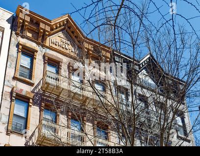 Les 249 et 251 East 77th Street sont des immeubles d'appartements en grès brun jumelé miroir de cinq étages avec des magasins au rez-de-chaussée dans l'Upper East Side. Banque D'Images