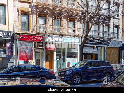 Les 249 et 251 East 77th Street sont des immeubles d'appartements en grès brun jumelé miroir de cinq étages avec des magasins au rez-de-chaussée dans l'Upper East Side. Banque D'Images