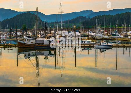 Hoonah, Icy Strait point Alaska États-Unis-29 juin 2019 : coucher de soleil et reflets des bateaux de pêche amarrés dans le port. Banque D'Images