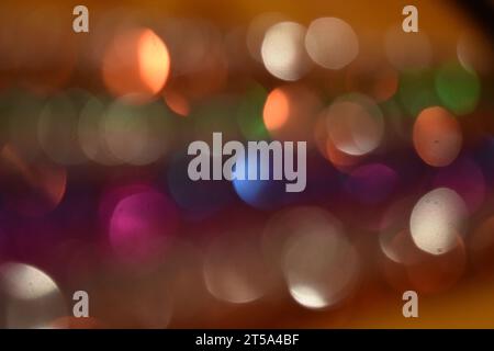 La lumière se reflète sur les rangées de guirlandes aux couleurs vives, créant un design abstrait et bokeh. Banque D'Images