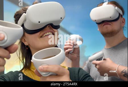 PRODUCTION - 19 octobre 2023, Saxe, Leipzig : dans une salle de classe numérique nouvellement créée au Centre de formation des enseignants et de recherche scolaire (ZLS) de l'Université de Leipzig, Sarah Bischof et Tobias Lammers testent des lunettes VR, qui sont présentées lors de séminaires destinés aux enseignants étudiants. La salle de classe numérique est équipée de la technologie moderne et est conçue pour montrer aux enseignants et aux étudiants les utilisations possibles de l’intelligence artificielle (IA) et l’utilisation de podcasts en classe à l’aide de la technologie vidéo, des iPads, des imprimantes 3D et des outils de réalité virtuelle, entre autres. L'enseignement prospectif Banque D'Images