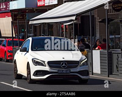 Melbourne Australie / Une Mercedes Sedan Pass clients dînant en plein air à Puckle Street, Moonee Ponds. Banque D'Images