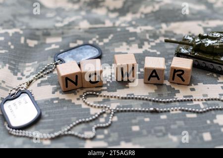 phrase no war est disposé sur des carrés de bois sur un fond gris avec drapeau de l'ukraine avec ruban bleu et jaune. Concept de paix, guerre en Ukraine Banque D'Images