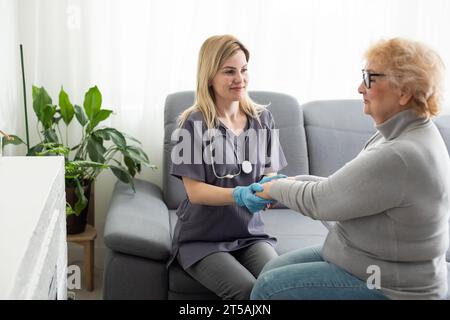 Jeune infirmière soignante médecin soignant aidant à tenir les mains d'une femme handicapée heureuse handicapée ou blessée âgée adulte ayant un problème de santé d'incapacité Banque D'Images