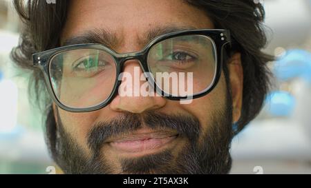 Gros plan du visage masculin positif dans les lunettes. Portrait Indien barbu homme dans des lunettes souriant regardant la caméra. Headshot entrepreneur homme d'affaires Banque D'Images