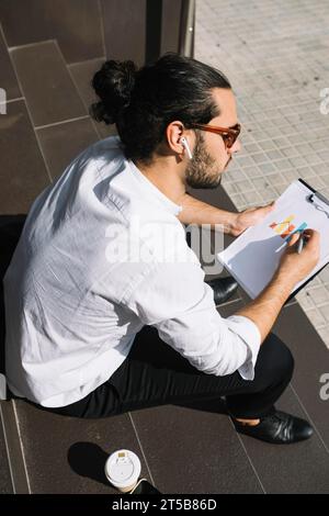 Vue aérienne homme d'affaires assis escalier dessin presse-papier graphique Banque D'Images