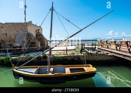 Bassins d'évaporation de sel et un vieux bateau en bois amarré à Marsala, Trapani, Sicile, Italie Banque D'Images