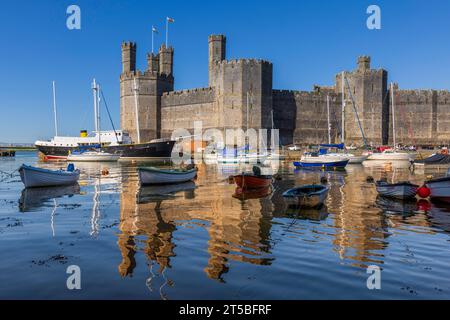 Le château de Caernarfon, classé au patrimoine mondial de l'UNESCO, est l'une des destinations touristiques les plus prisées du pays de Galles. Banque D'Images