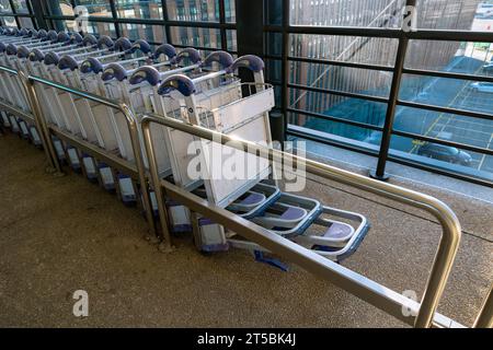 Rangée de chariots à bagages ou chariots d'aéroport ou chariots à bagages dans un aéroport. Photo de fond du concept de voyage. Banque D'Images