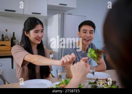 Des amis font un repas à la cuisine. Alimentation saine et concept d'activités de loisirs. Banque D'Images