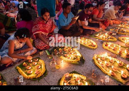 Dhaka, Bangladesh. 4 novembre 2023. Les dévots hindous s'assoient avec Prodip (lumières) et prient Dieu pour le bien-être de la famille devant le temple Shri Shri Lokanath Brahmachari Ashram, Swamibag, Dhaka pendant le Kartik Brati ou Rakher Upobash, un festival religieux hindou de jeûne organisé chaque année à la dernière moitié du mois bengali Kartik. Les dévots s'assoient avec de la nourriture et des bougies et prient sincèrement le Dieu avant de rompre le jeûne. Lokenath Brahmachari qui est appelé Baba Lokenath était un saint hindou du 18e siècle et philosophe au Bengale. Les dévots de Lokenath Brahmachari prient avec lumière pour sauver leur famille Banque D'Images