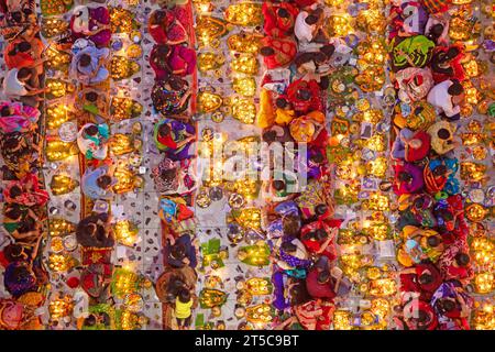 Dhaka, Bangladesh. 4 novembre 2023. Les dévots hindous s'assoient avec Prodip (lumières) et prient Dieu pour le bien-être de la famille devant le temple Shri Shri Lokanath Brahmachari Ashram, Swamibag, Dhaka pendant le Kartik Brati ou Rakher Upobash, un festival religieux hindou de jeûne organisé chaque année à la dernière moitié du mois bengali Kartik. Les dévots s'assoient avec de la nourriture et des bougies et prient sincèrement le Dieu avant de rompre le jeûne. Lokenath Brahmachari qui est appelé Baba Lokenath était un saint hindou du 18e siècle et philosophe au Bengale. Les dévots de Lokenath Brahmachari prient avec lumière pour sauver leur famille Banque D'Images