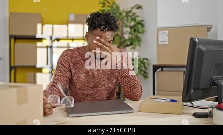 Homme afro-américain travailleur d'affaires de commerce électronique finissant au travail stressé au bureau Banque D'Images