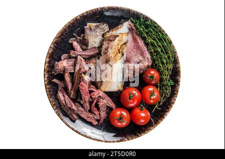 Côtes courtes de bœuf fumé dans une assiette rustique avec des herbes. Isolé sur fond blanc. Banque D'Images