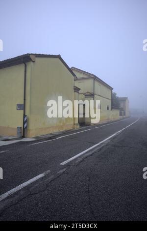Manoir au bord d'une route par une journée brumeuse dans la campagne italienne Banque D'Images