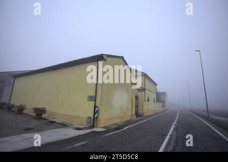 Manoir au bord d'une route par une journée brumeuse dans la campagne italienne Banque D'Images