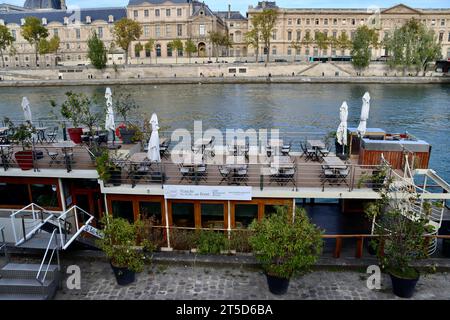 Restaurant flottant Peniche la balle ou Bond sur la Seine avec Musée du Louvre sur la rive opposée à Paris, France Banque D'Images