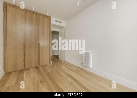 Chambre vide avec armoire intégrée construite sur mesure avec portes en bois de chêne clair, climatisation canalisée au plafond Banque D'Images