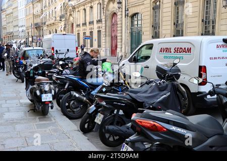 Homme blond texto sur moto garée sur Faubourg Saint-honore à Paris, France Banque D'Images