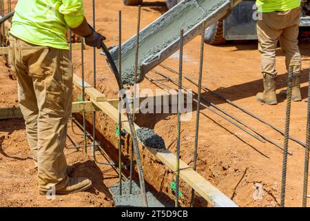 Couler le mélange de béton pour la nouvelle fondation de maison sur le chantier de construction par le travailleur Banque D'Images