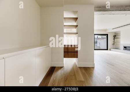 salon vide avec étagères en bois personnalisées entre un pilier Banque D'Images