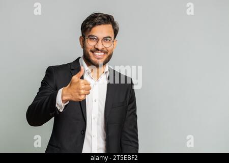 J'aime. L'homme d'affaires indien soulève les pouces vers le haut est d'accord avec quelque chose ou donne une réponse positive recommande la publicité aime la rétroaction de bonne idée, célébrant la victoire de succès. Homme isolé sur fond gris Banque D'Images
