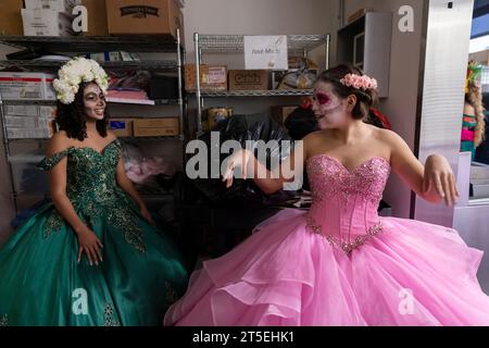 Seattle, Washington, États-Unis. 4 novembre 2023. Deux jeunes femmes discutent en attendant dans une cuisine le début d’un défilé Catrina à la célébration annuelle du Día de los Muertos au Centro de la Raza. Crédit : Paul Christian Gordon/Alamy Live News Banque D'Images