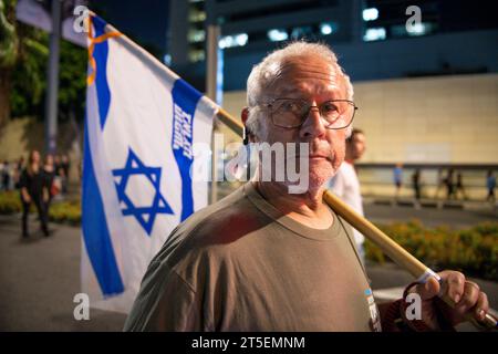 Tel Aviv, Israël. 04 novembre 2023. Un homme adulte marche avec le drapeau israélien lors de la manifestation pour la libération des otages du Hamas le 7 octobre. La manifestation pour la libération des otages du Hamas enlevés le 7 octobre est l'une des plus importantes et des plus nombreuses depuis le début de la guerre. Famille, amis et membres de la société civile ont exigé que le gouvernement de Benjamin Netanyahu trouve une solution immédiate pour ramener les 200 otages vivants. (Photo Israel Fuguemann/SOPA image/Sipa USA) crédit : SIPA USA/Alamy Live News Banque D'Images