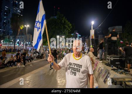 Tel Aviv, Israël. 04 novembre 2023. Daniel porte un drapeau israélien et une chemise avec un message qui dit revenir maintenant. La manifestation pour la libération des otages du Hamas enlevés le 7 octobre est l'une des plus importantes et des plus nombreuses depuis le début de la guerre. Famille, amis et membres de la société civile ont exigé que le gouvernement de Benjamin Netanyahu trouve une solution immédiate pour ramener les 200 otages vivants. Crédit : SOPA Images Limited/Alamy Live News Banque D'Images