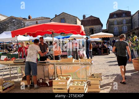 Marché dans la bastide de Monpazier. Jour de marché sur la place des cornières (place centrale) de la bastide de Monpazier en Périgord. Le hist Banque D'Images