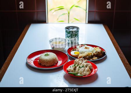 Menu composé de plats ou de plats typiques malaisiens. Nasi Hainan, Nasi Lemak, et une tasse de café. Banque D'Images