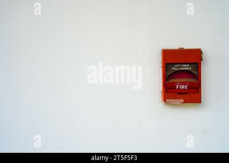 L'ancienne alarme incendie est toujours attachée au mur blanc. Défaillance de l'alarme incendie Banque D'Images