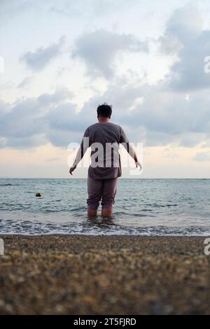 Vue arrière d'un homme contemplant sur la plage vue arrière d'un homme contemplant sur la plage Banque D'Images