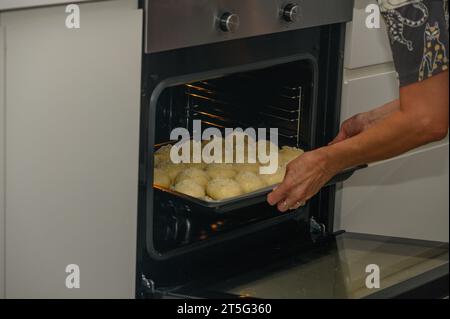 femme met les petits pains au four sur une plaque de cuisson 3 Banque D'Images