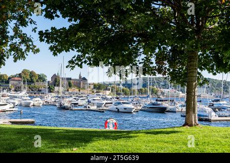 Oslo, Norvège : bateaux amarrés et yachts à Aker Brygge District, Château Akershus en arrière-plan (Akershus festning) Banque D'Images