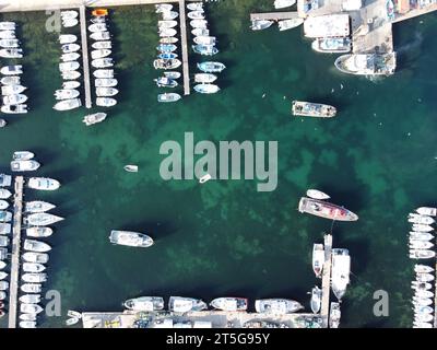 Vue aérienne de haut en bas des bateaux de pêche, des yachts et des motifs d'algues à l'intérieur d'une marina dans le port de Carro sur la Côte d'Azur Banque D'Images