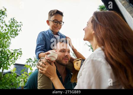 Père porte son fils avec des gadgets de baseball sur ses épaules Banque D'Images