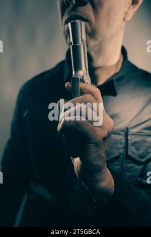 Mercenaire tueur espion assasin détective avec photo de studio de portrait d'arme à feu. Banque D'Images