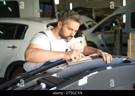 Detailer de voiture expérimenté polir la partie de carrosserie d'automobile Banque D'Images