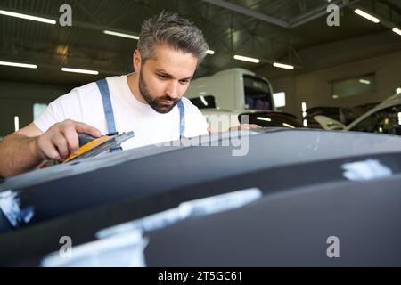 Professionnel automobile Detailer polir la partie de carrosserie de voiture avec l'outil Banque D'Images