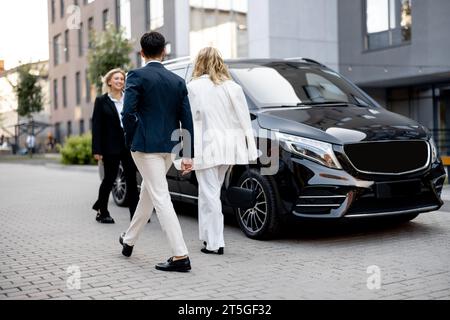 Les gens d'affaires se rendent à pied au taxi minibus Banque D'Images