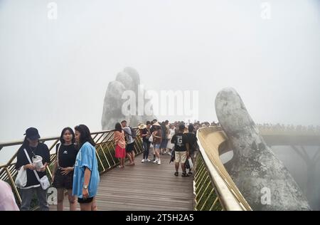 Danang, Vietnam - 27 juin 2023 : le pont d'or est soulevé par deux mains géantes dans la station touristique sur la colline de Ba Na Banque D'Images